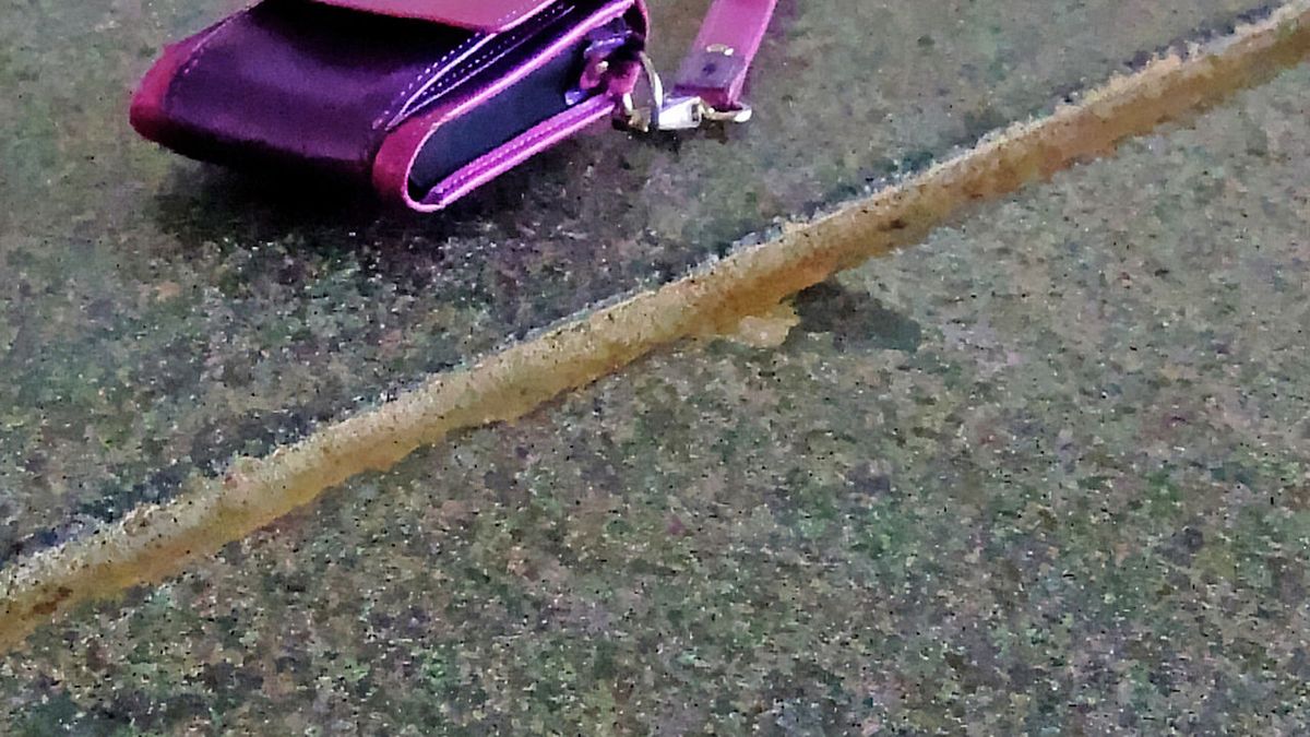 A lost wallet dropped on a stone walkway beside water